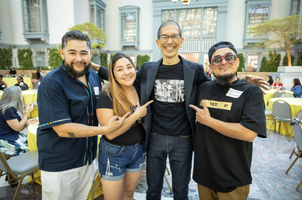 Akito Tsuda and three reception attendees standing side by side smiling.